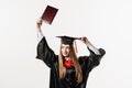 Graduate girl is graduating college and celebrating academic achievement. Happy girl student in black graduation gown Royalty Free Stock Photo