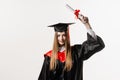 Graduate girl is graduating college and celebrating academic achievement. Happy girl student in black graduation gown Royalty Free Stock Photo