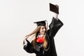 Graduate girl is graduating college and celebrating academic achievement. Happy girl student in black graduation gown Royalty Free Stock Photo