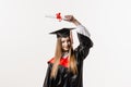 Graduate girl is graduating college and celebrating academic achievement. Happy girl student in black graduation gown Royalty Free Stock Photo