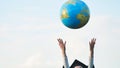 Graduate girl tosses the globe up. Royalty Free Stock Photo