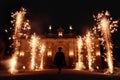 Graduate person in silhouette walking towards grand building with fireworks. Celebration, grandeur, majestic entrance