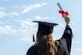 Graduate put her hands up and celebrating with certificate in her hand and feeling so happiness in Commencement day. Toned Royalty Free Stock Photo