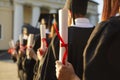 Graduate.Selective focus on degree diploma certificate in hand of student standing in row