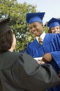 Graduate shaking hand of dean outside