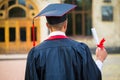 Graduate student hands holding diploma from the back