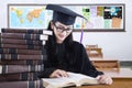 Graduate student with mortarboard reading books