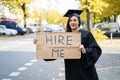 Graduate Student Standing With Hire Me Placard