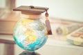 Graduate study abroad concept, Graduation cap on top Earth globe Royalty Free Stock Photo