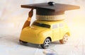 Graduate study abroad inter school concept : Graduation cap over yellow car on Bangkok city map, road to succes in life.