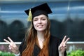 Graduate young girl with red hair dressed in mantle and square academic cap smile in university campus Royalty Free Stock Photo