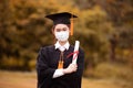 Graduated woman wear cap gown and Medical mask for protection virus holding diploma or certificated due Virus outbrake Royalty Free Stock Photo