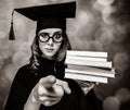 Graduating student girl in an academic gown with books Royalty Free Stock Photo
