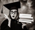 Graduating student girl in an academic gown with books Royalty Free Stock Photo