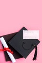 Graduation academic cap with diploma and mask isolated on pink table background Royalty Free Stock Photo