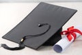 Graduation academic cap with diploma on wooden table background Royalty Free Stock Photo