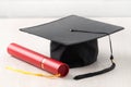 Graduation academic cap with diploma on wooden table background Royalty Free Stock Photo