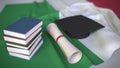 Graduation cap, books and diploma on the Italian flag. Higher education in Italy related conceptual 3D rendering