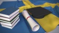 Graduation cap, books and diploma on the Swedish flag. Higher education in Sweden related conceptual 3D rendering