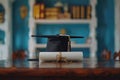 Graduation cap and diploma with red ribbon on wooden table with bokeh lights background Royalty Free Stock Photo