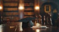 Graduation cap and diploma with red ribbon on wooden table with bokeh lights background Royalty Free Stock Photo