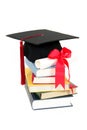 Graduation cap and diploma on stack of books