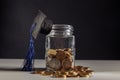 Graduation cap on jar with coins. Scholarship money concept