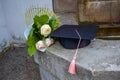 Graduation cap or mortaboard with a bunch of roses on the old stairs  in the graduation day Royalty Free Stock Photo