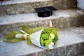 Graduation cap or mortaboard with a bunch of roses on the old stairs  in the graduation day Royalty Free Stock Photo