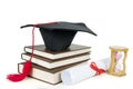 Graduation cap on a pile of books with hourglass