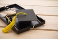 Graduation cap in a rat trap on wooden table background. College or university degrees are not important in future, education loan