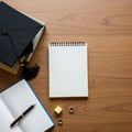 Graduation cap rests on a closed stack of books on a wooden surface. An open Royalty Free Stock Photo