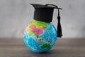 Graduation cap on top of world globe with copy space. Royalty Free Stock Photo