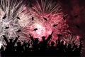 Graduation ceremony, fireworks in night sky. Silhouette of happy graduate students throwing academic square caps