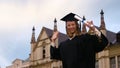 Graduation: Girl is being photographed in front of the college.