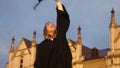 Graduation - girl throws her hat in the air and smiles to camera