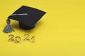 Graduation 2021. Graduate cap on a yellow background. Graduate Template 2021