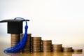 Graduation hat on coins money on white background.