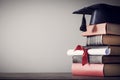 Graduation hat and diploma with book on table Royalty Free Stock Photo