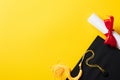 Graduation hat and diploma on yellow background. Flat lay, top view