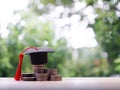 Graduation hat on stack of coins. The concept of saving money for education, student loan, scholarship, tuition fees in future Royalty Free Stock Photo