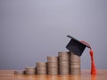 Graduation hat on stack of coins. The concept of saving money for education, student loan, scholarship, tuition fees in future Royalty Free Stock Photo