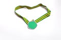 Graduation medal with green and yellow ribbons on white background