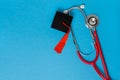 graduation medical concetp. Graduation cap and stethoscope on blue background