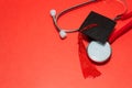 graduation medical concetp. Graduation cap and stethoscope on red background