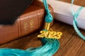 a 2023 graduation tassel on a bible with a cap