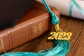 a 2023 graduation tassel on a bible with a cap