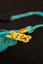 a 2023 graduation tassel on black