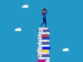 Graduation. Woman holding graduation cap standing on high pile of books Royalty Free Stock Photo