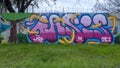 Graffiti on a barbed wire topped wooden fence on Fabrication Street in Dallas, Texas.